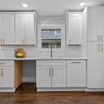 Bright white custom kitchen cabinets with gold hardware at Premium Cabinet Studio.