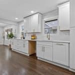 Luxurious white custom kitchen cabinets with gold hardware,modern design, and ample storage space.