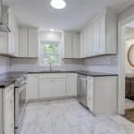 Bright white custom kitchen cabinets with modern design and black countertops for a stylish look.