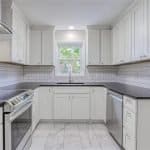 Bright white custom kitchen cabinets with sleek countertops and subway tile backsplash from Premium Cabinet Studio.