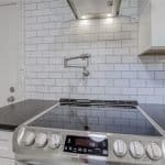 Sleek modern kitchen with custom cabinets and white subway tile backsplash.
