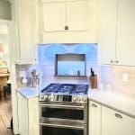 Natural white kitchen cabinets with modern design and stainless steel appliances, custom cabinet storage solutions.