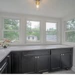 Bright kitchen with black cabinets and large window views | Premium Cabinet Studio.