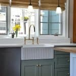 Bright kitchen with elegant green cabinets and gold fixtures, perfect for modern home design.