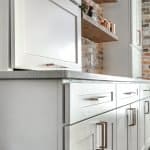 Sleek white cabinetry with gold hardware, modern kitchen cabinets, and a durable granite countertop.