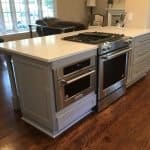 Stainless steel appliances with custom gray kitchen cabinets at Premium Cabinet Studio.