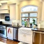 Custom kitchen cabinets with elegant white finishes and dark countertops, featuring premium craftsmanship.