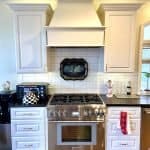 Elegant white kitchen cabinets with crown molding, custom cabinetry, and stainless steel appliances.