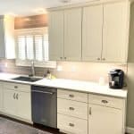 Elegant cream kitchen cabinets with stainless steel appliances and a coffee station, showcasing custom cabinet design.