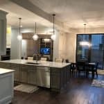 Elegant kitchen with custom cabinetry, spacious island, modern lighting, and open-concept living space.