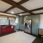 Handcrafted kitchen cabinets with a green finish and red accents, custom storage solutions, premium cabinetry design.