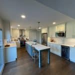 Contemporary white kitchen cabinets with modern appliances and a central island for versatile cooking space.