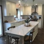Bright white kitchen cabinets with modern farmhouse style, premium countertops, and stylish lighting fixtures.
