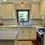 Contemporary white kitchen cabinets with modern hardware, featuring a bright, airy design and elegant backsplash.