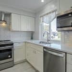 Stainless steel kitchen appliances with custom white cabinets for modern kitchen design.