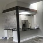 Modern kitchen with custom cabinets and sleek black countertops for premium home renovation.