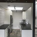 Modern kitchen with custom white cabinets and black quartz countertops for premium cabinets.