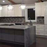 Elegant white kitchen cabinets with marble island and modern backsplash in premium cabinet studio.