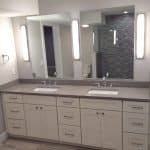 Modern double vanity bathroom with custom cabinets and sleek lighting.