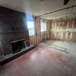 Gutted living area with original brick fireplace during a Raytown, MO kitchen remodel, walls stripped to studs before renovation
