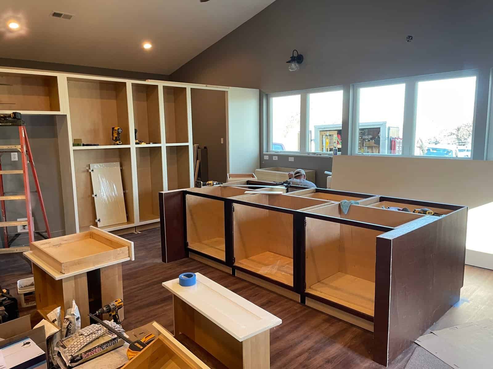 Kitchen remodel in progress in Kansas City, MO — large island cabinet boxes and pantry cabinets being installed with espresso trim accents