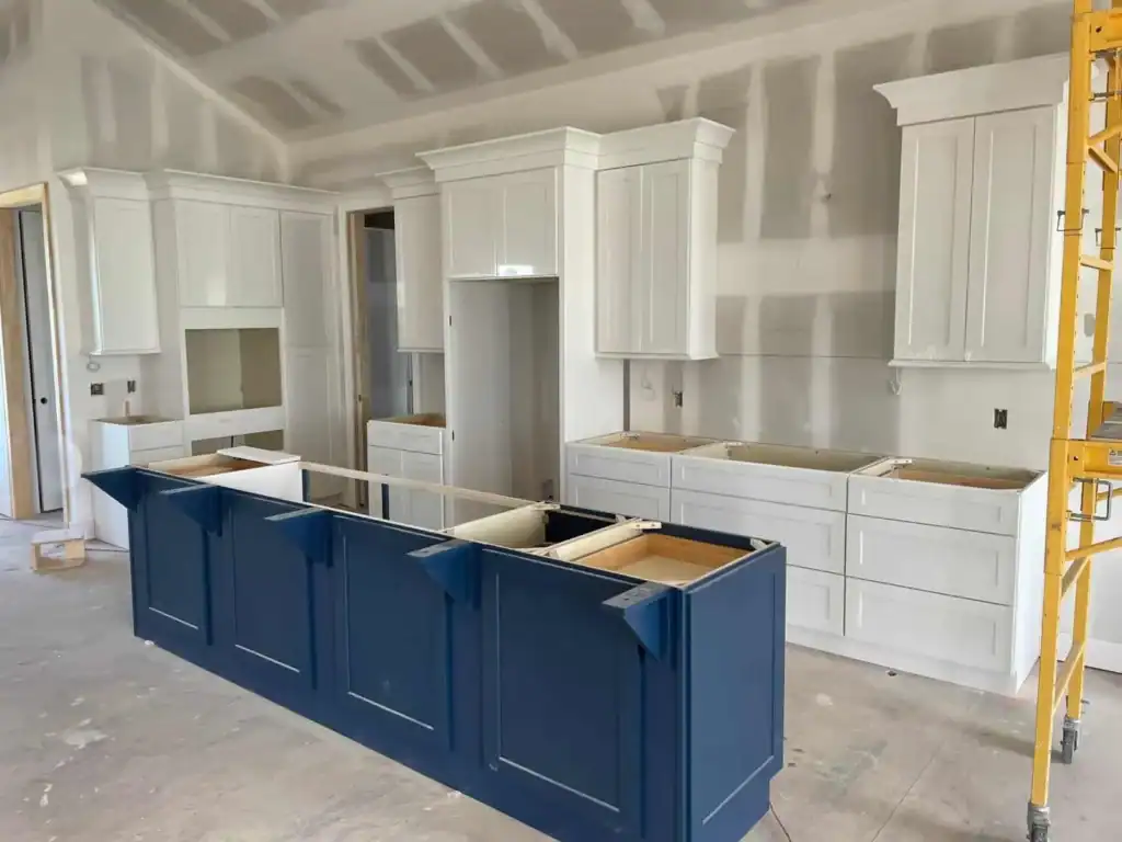 Kitchen cabinet replacement timeline in Overland Park, KS — white perimeter cabinets and navy island installed, ready for countertops