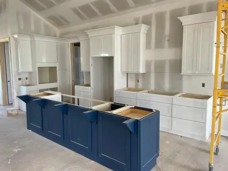 Kitchen cabinet replacement timeline in Overland Park, KS — white perimeter cabinets and navy island installed, ready for countertops