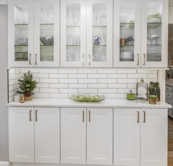 White shaker style kitchen cabinets with complimenting white subway tile and white quartz countertop
