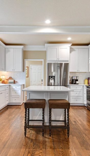 White shaker kitchen cabinets with island and hardwood floors – Overland Park, KS kitchen remodel