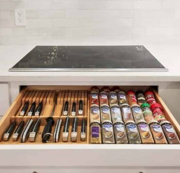 White shaker kitchen cabinets in Olathe, KS, featuring a cooktop pull-out, knife storage, and spice drawer.